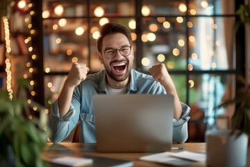 Fototapeta premium Excited young man looking at laptop screen. Handsome overjoyed guy feeling happy about his work.