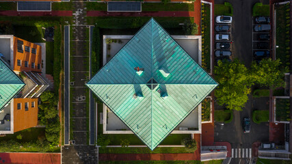 Perpendicular aerial view of the roof of a building. The roof has a square rhombus shape.