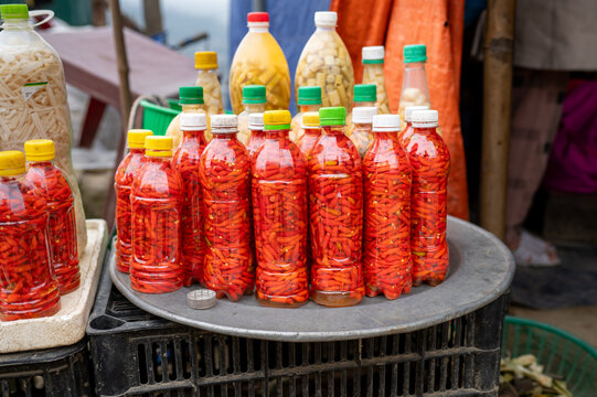 Plastic bottles of pickled red hot peppers