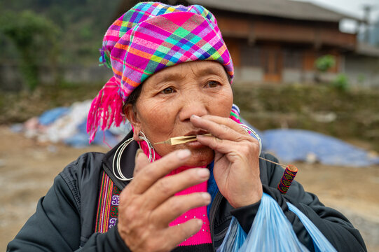 Middle aged ethnic woman playing lip lute