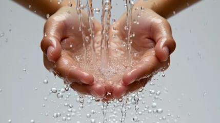 Poster A person's hands holding water with a grey background © Adobe Contributor