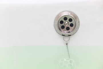 bathtub with drain hole filled with water