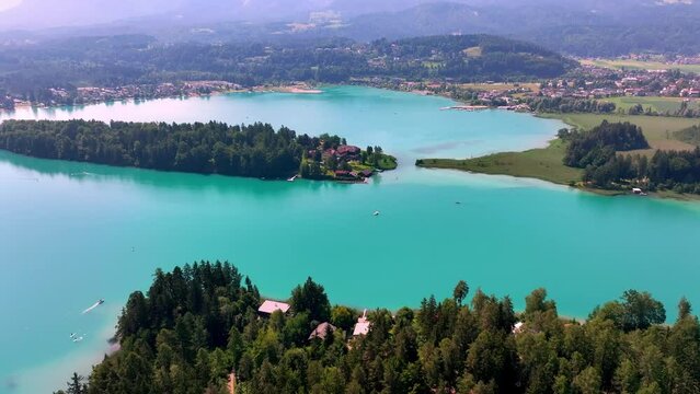 aerial shot of faak's lake in the mountains in Austria on sunrise