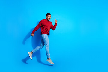 Fototapeta na wymiar Full length profile portrait of nice satisfied person jump run empty space ad isolated on blue color background