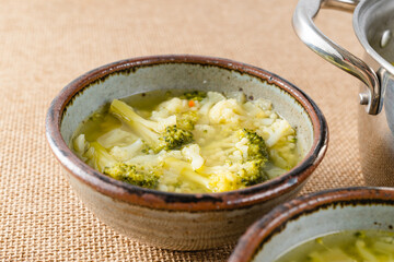 Bowl of cauliflower broccoli soup close-up on a table