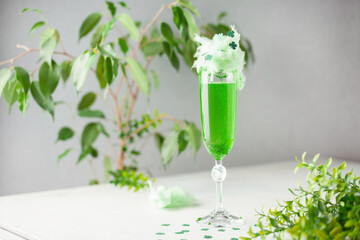 Glass of green champagne with cotton candy on the table. St. Patrick's Day Concept