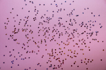 Pink pastel background with small hearts confetti. Flatlay, top view, copy space