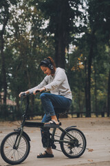 Happy Asian young woman walk and ride bicycle in park, street city her smiling using bike of transportation, ECO friendly, People lifestyle concept.