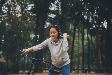 Fototapeta premium Happy Asian young woman walk and ride bicycle in park, street city her smiling using bike of transportation, ECO friendly, People lifestyle concept.
