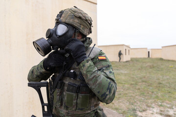 Un soldado español se coloca la mascara antigás durante unas maniobras militares.