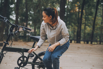 Happy Asian young woman walk and ride bicycle in park, street city her smiling using bike of...