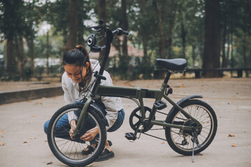 Fototapeta premium Happy Asian young woman walk and ride bicycle in park, street city her smiling using bike of transportation, ECO friendly, People lifestyle concept.