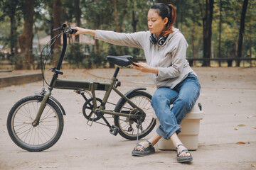 Happy Asian young woman walk and ride bicycle in park, street city her smiling using bike of transportation, ECO friendly, People lifestyle concept.