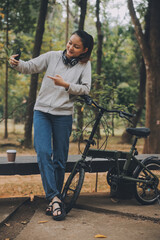 Happy Asian young woman walk and ride bicycle in park, street city her smiling using bike of transportation, ECO friendly, People lifestyle concept.