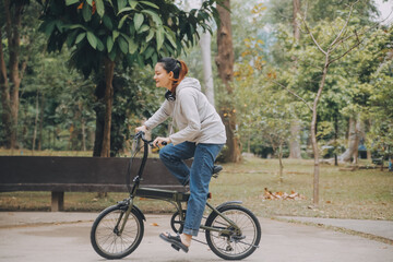 Fototapeta premium Happy Asian young woman walk and ride bicycle in park, street city her smiling using bike of transportation, ECO friendly, People lifestyle concept.