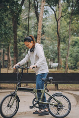 Happy Asian young woman walk and ride bicycle in park, street city her smiling using bike of transportation, ECO friendly, People lifestyle concept.