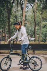 Fototapeta premium Happy Asian young woman walk and ride bicycle in park, street city her smiling using bike of transportation, ECO friendly, People lifestyle concept.