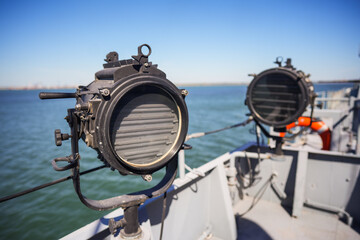 Military ship search light on the deck