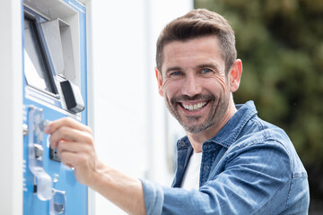 man entering coin into payment meter