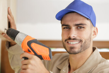 close portrait of young tradesman using drill