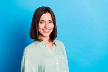 Portrait of cheerful lovely girl with stylish hairdo wear turquoise blouse toothy smiling at camera isolated on blue color background