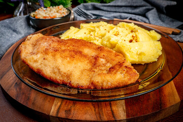 Breaded chicken breast fillet served with boiled potatoes and salad.
