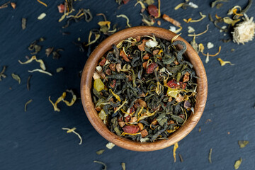 Obraz na płótnie Canvas dry green tea with jasmine flowers, calendula, pineapple slices