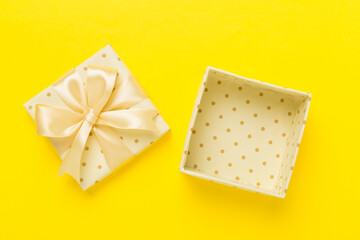 Beige open gift box on color background, top view