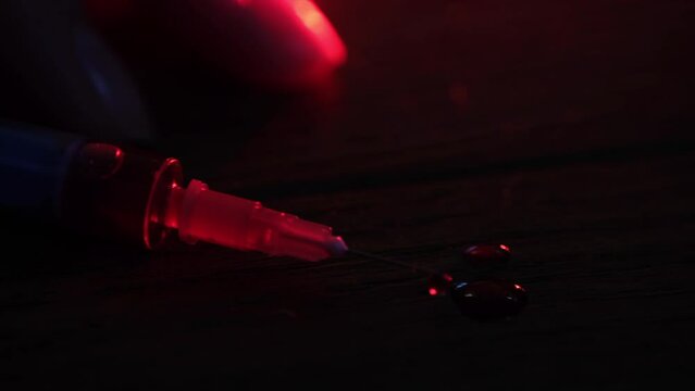 A syringe illuminated by police lights.