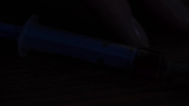 A syringe illuminated by police lights.