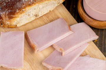 slicing a finished piece of ham into small pieces