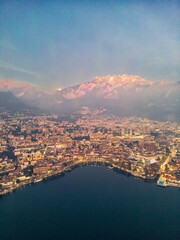 Drone shot of the city of Lecco and Lake Como at dusk, Italy. Mount Resegone in the background