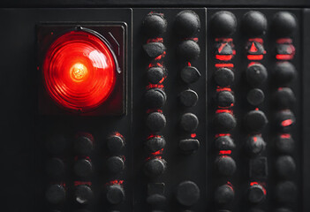 Vivid Vigilance: Red Alert Lamp or Warning Indicator Glowing on Black Panel &ndash; A Striking Visual Signal of Urgency and Caution