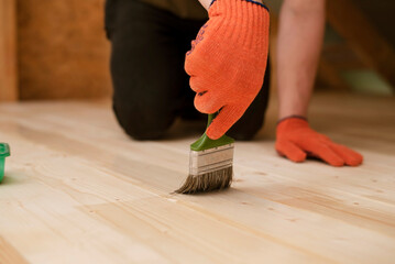 Lacquering a wooden floor with transparent varnish to give the wood stability and strength and to prevent the color of the wood from changing