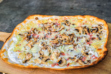 Flammekueche or tarte flambee with fromage blanc cheese, bacon and mushrooms at an outdoor restaurant, Riquewihr, France, Alsatian Wine Route village