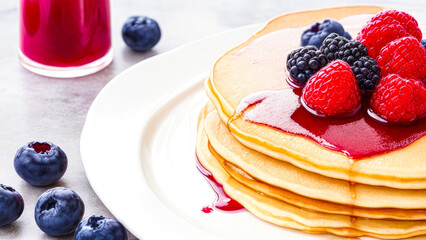 Stack of Pancakes with berry jam and fresh berries, served on a plate on the table. Pancakes with berries, sweet breakfast food