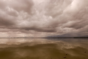 dramatic sky is reflecting in the water surface of a lake in Amboseli NP