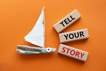 Tell your story symbol. Wooden blocks with words Tell your story. Beautiful orange background with...