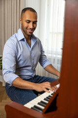 Man practicing playing piano in living room of his home relaxing from work