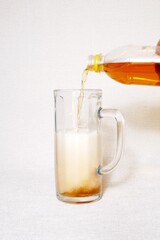 Pouring beer from a plastic bottle into a glass 0.5 liter glass.