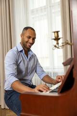 Man enjoying playing piano at home plays music on musical instrument