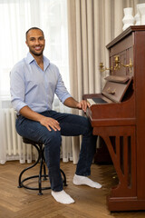 Man enjoying playing piano at home plays music on musical instrument