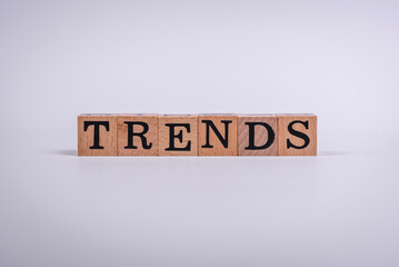 The inscription Trend made of wooden cubes on a plain background