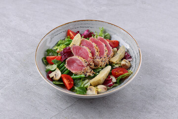 salad with carpaccio, artichoke and asparagus on a stone background, studio food photography 2