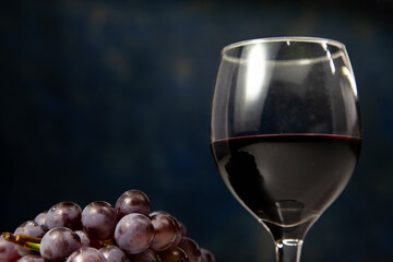 Bunch of grapes with glass of wine next to it. Clean space for text.