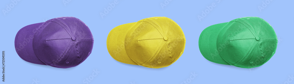 Sticker Stylish baseball caps on light blue background, top view