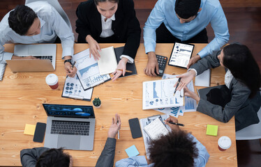 Multiracial analyst team use BI Fintech software to analyze financial data on meeting. Top view...