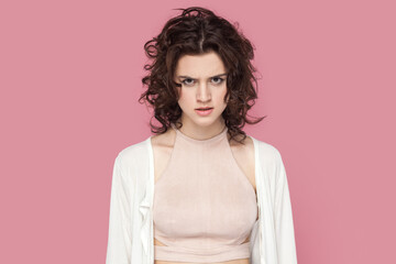 Portrait of angry aggressive woman with curly hairstyle wearing casual style outfit looking at...