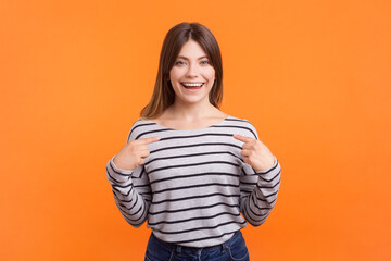 Portrait of happy positive smiling woman with brown hair pointing at herself, being ready to be...