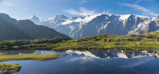 reflet des glaciers de la Meije sur un lac du plateau d'Emparis au refuge des Mouterres dans les Alpes en été	